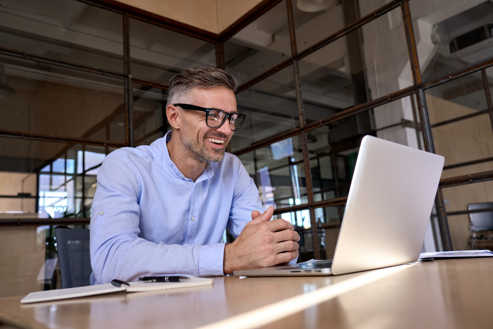 A Virtual Assistant is sitting at a table using a laptop computer.