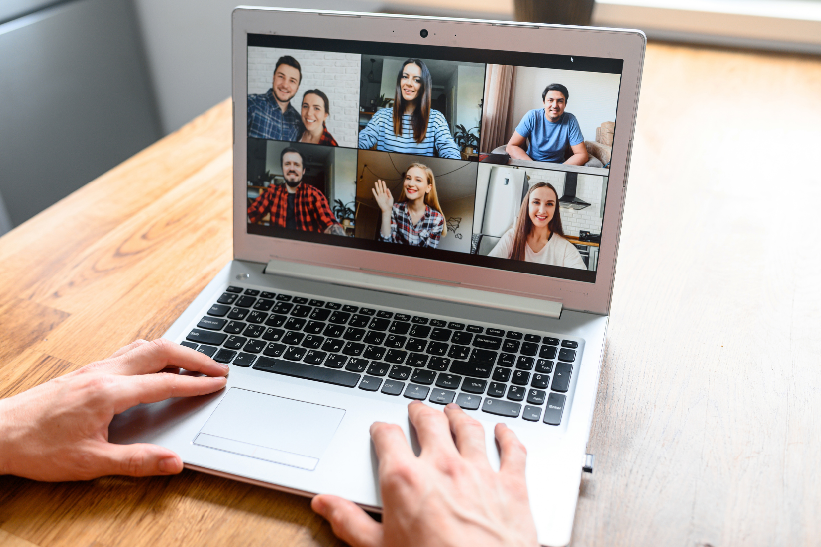 A Virtual Assistant is using a laptop computer to have a video call with a group of people.