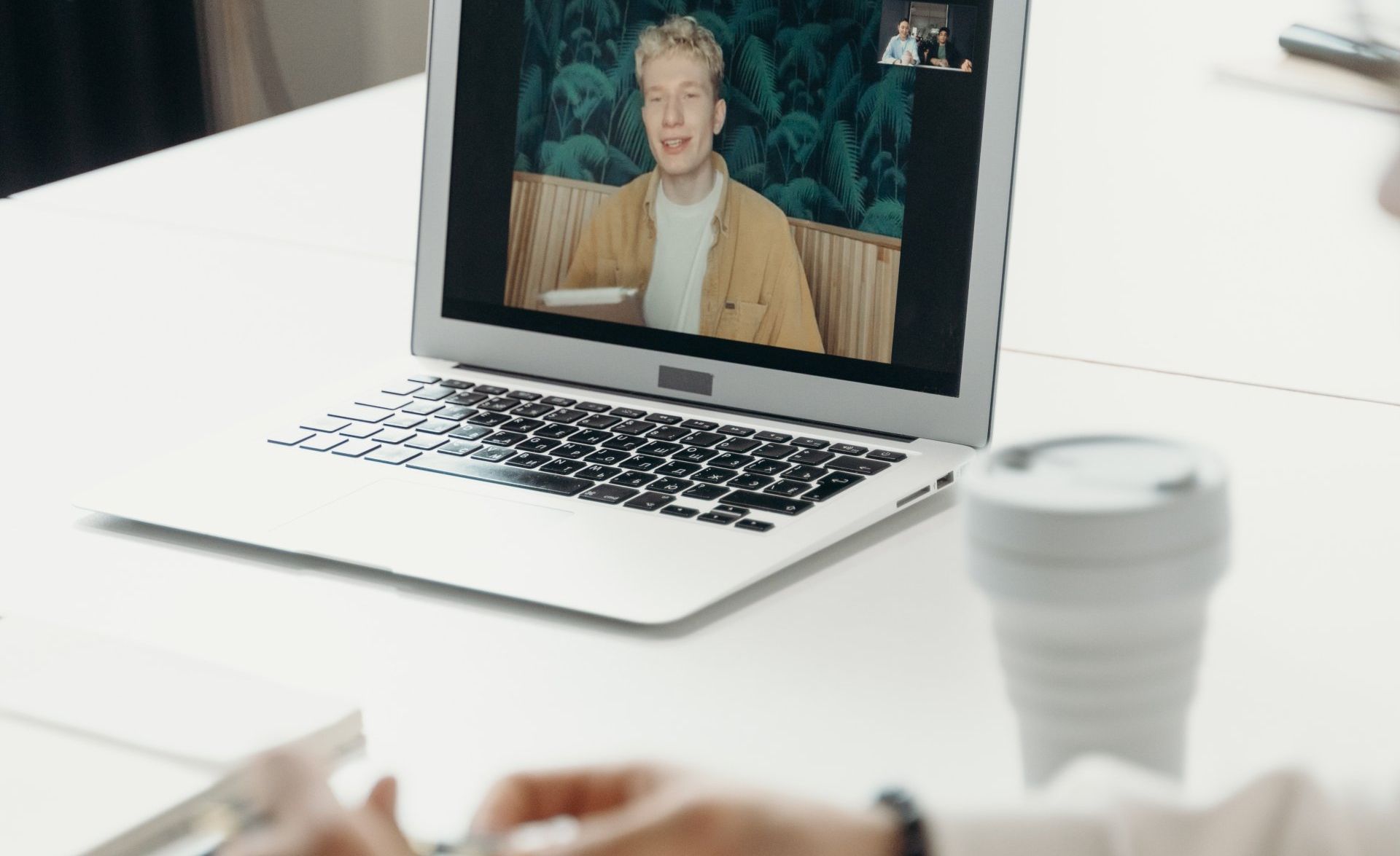 A Virtual Assistant is sitting at a desk using a laptop computer.