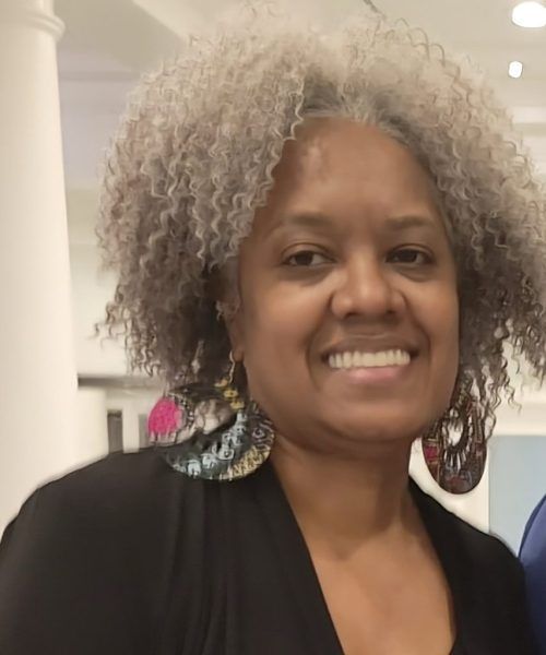 Finger placed on a biometric scanner on a white wall, near a window.