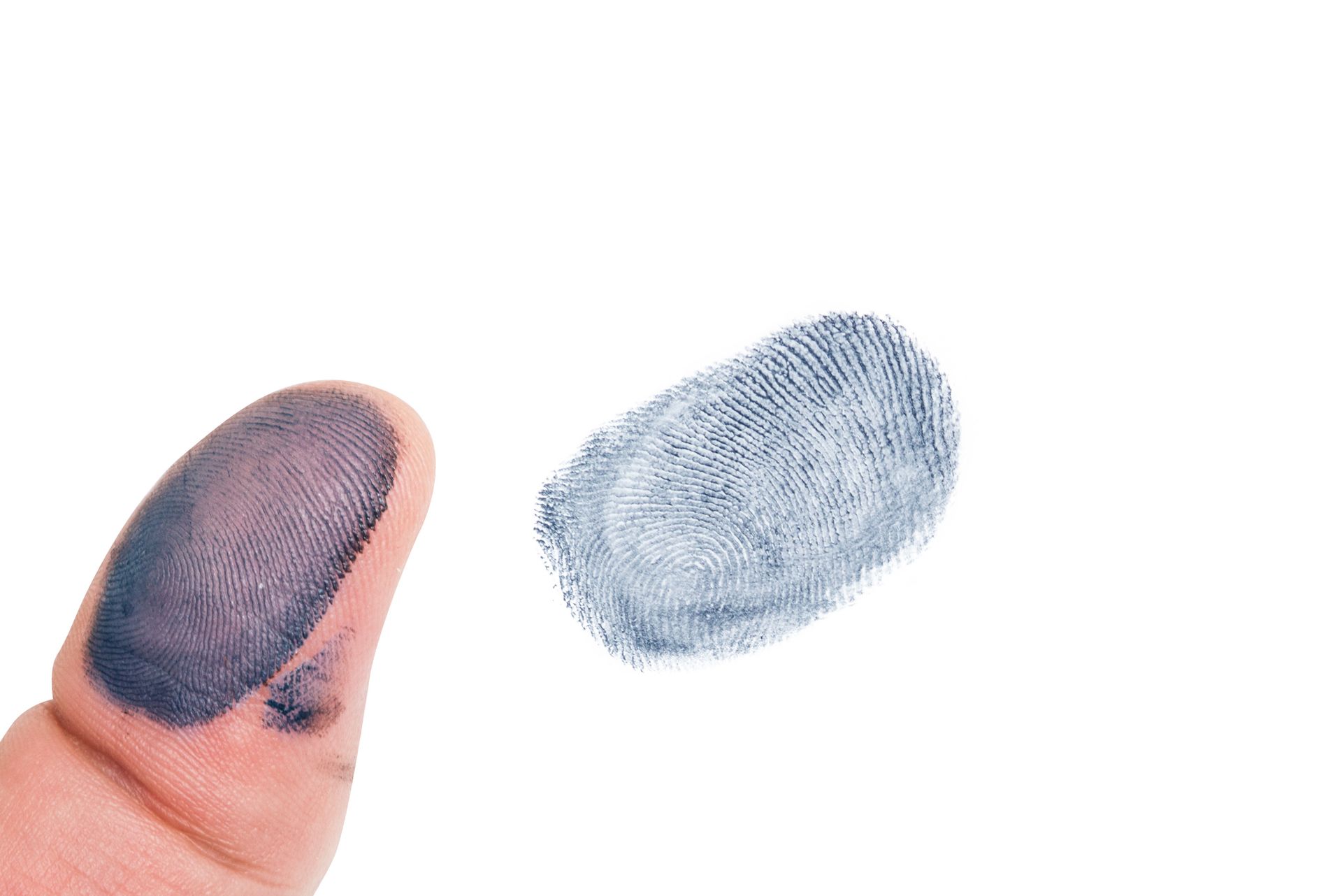 Thumb with dark print next to a blue fingerprint on white background.