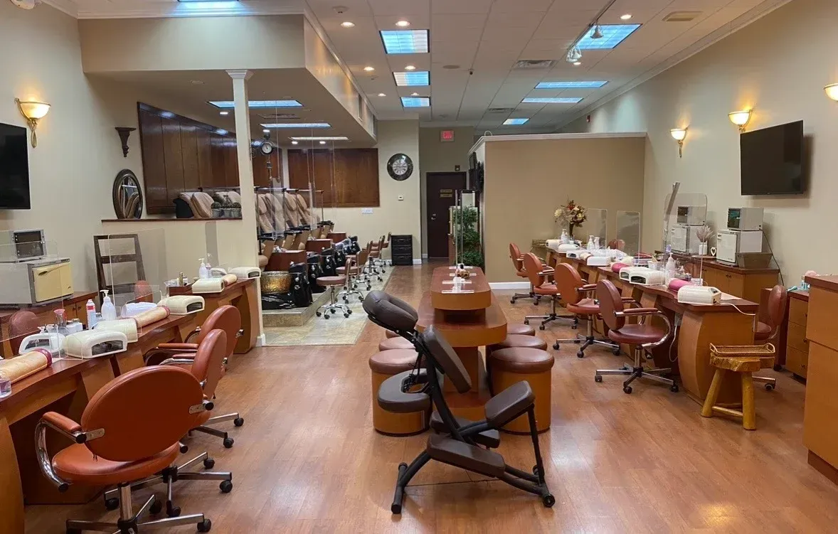 Modern salon interior with styling chairs, mirrors, sinks, and warm wood flooring