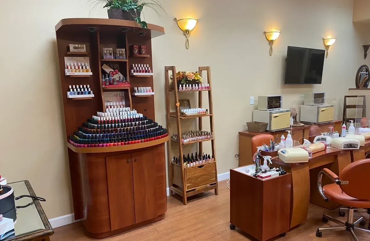 Salon interior with styling stations, product display shelves, and warm wall sconces