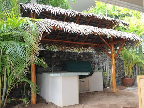 A thatched gazebo with a table underneath it
