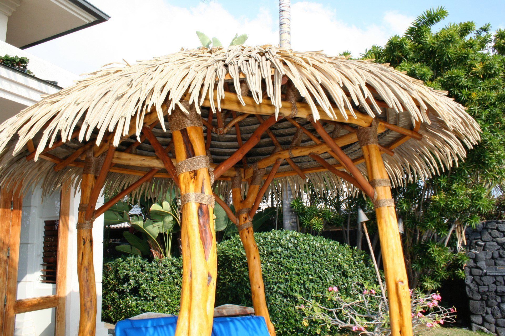 A wooden gazebo with a thatched roof