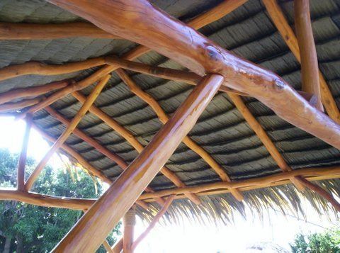 A wooden structure with a thatched roof and wooden beams