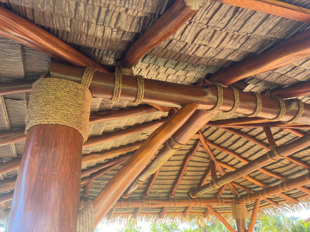 A wooden structure with a thatched roof and wooden beams.