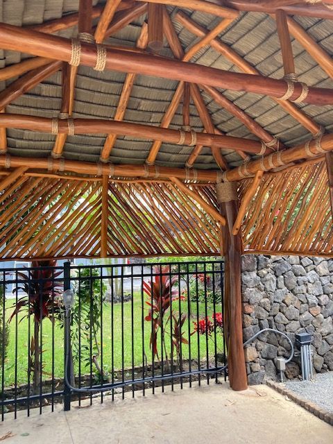 A wooden gazebo with a metal fence around it