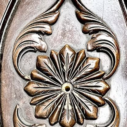 A close up of a carving of a flower on a piece of wood