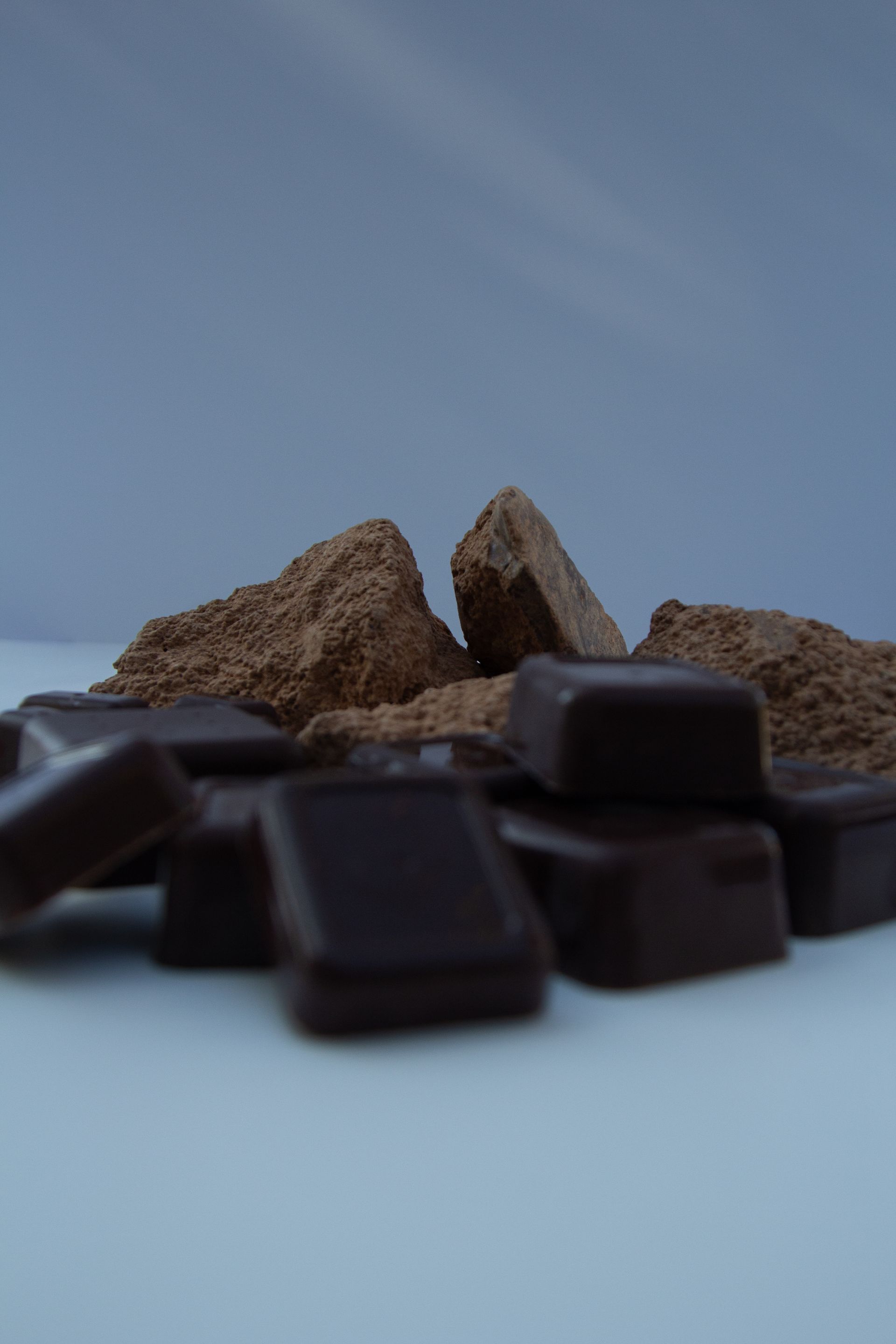 A pile of chocolate pieces on a white surface