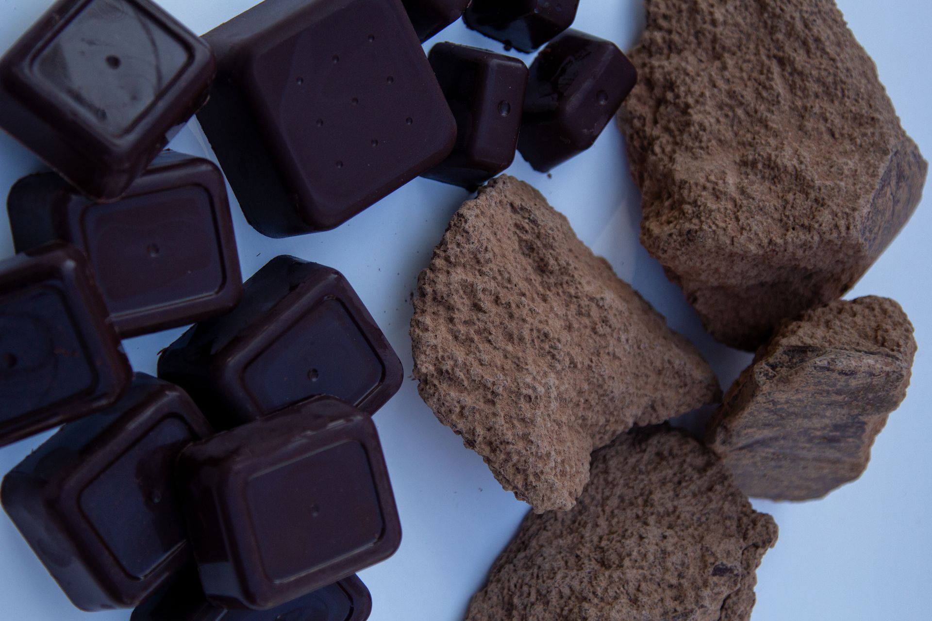 A pile of chocolate pieces and a pile of cocoa powder