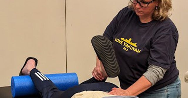 Lauren stretching client's leg