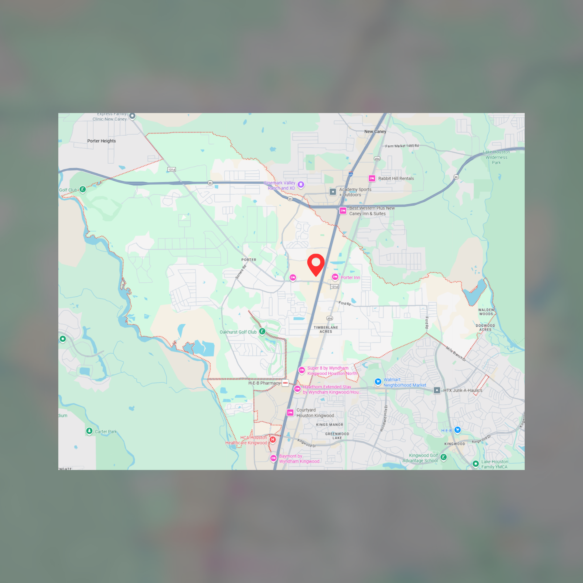 Map with red pin, indicating a location within a town, showing roads, buildings, and surrounding nature.