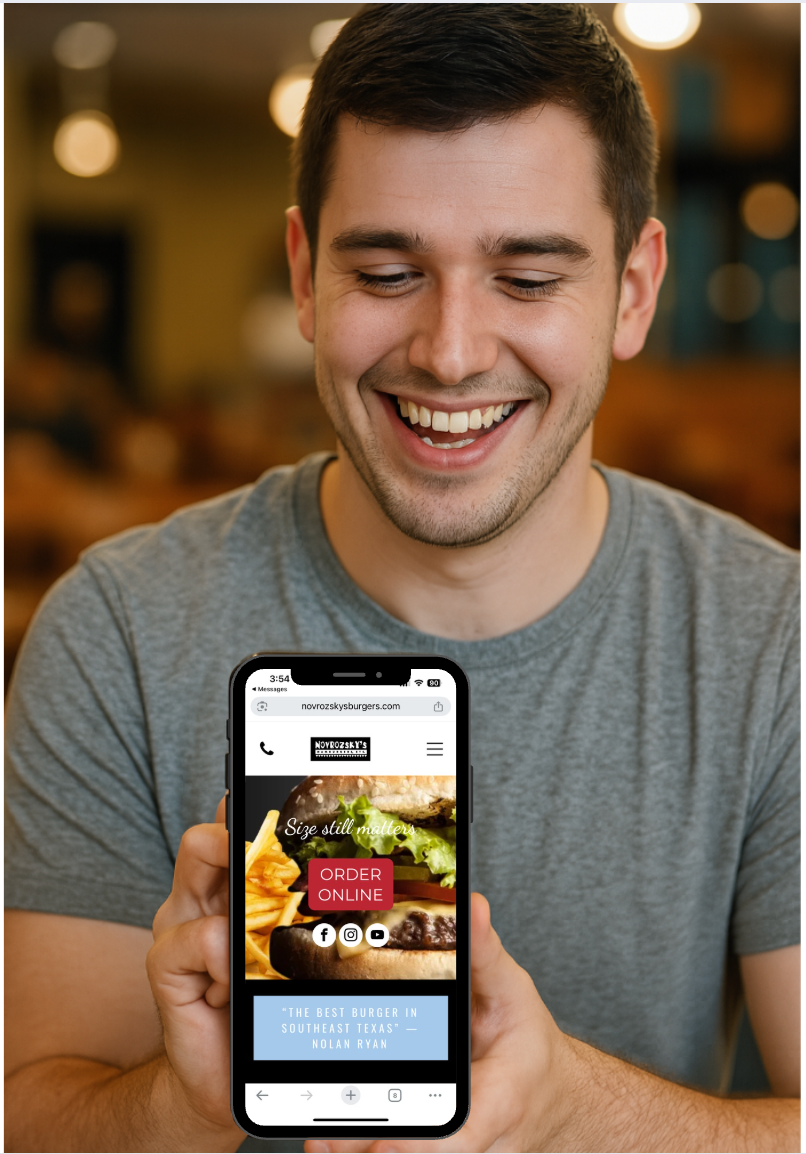 A man is holding a cell phone in his hand and smiling.