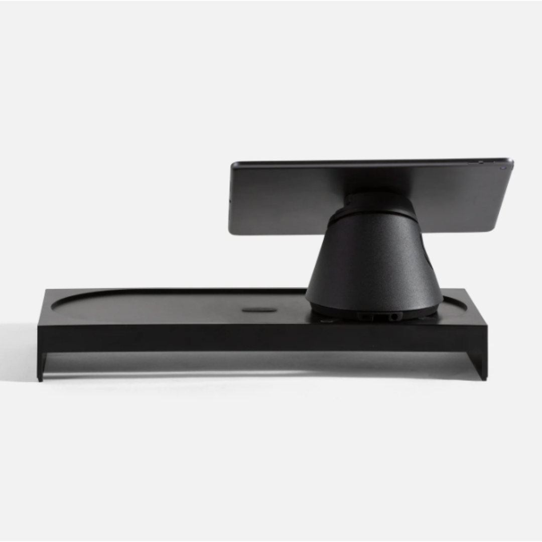 A black tablet is sitting on top of a black stand.