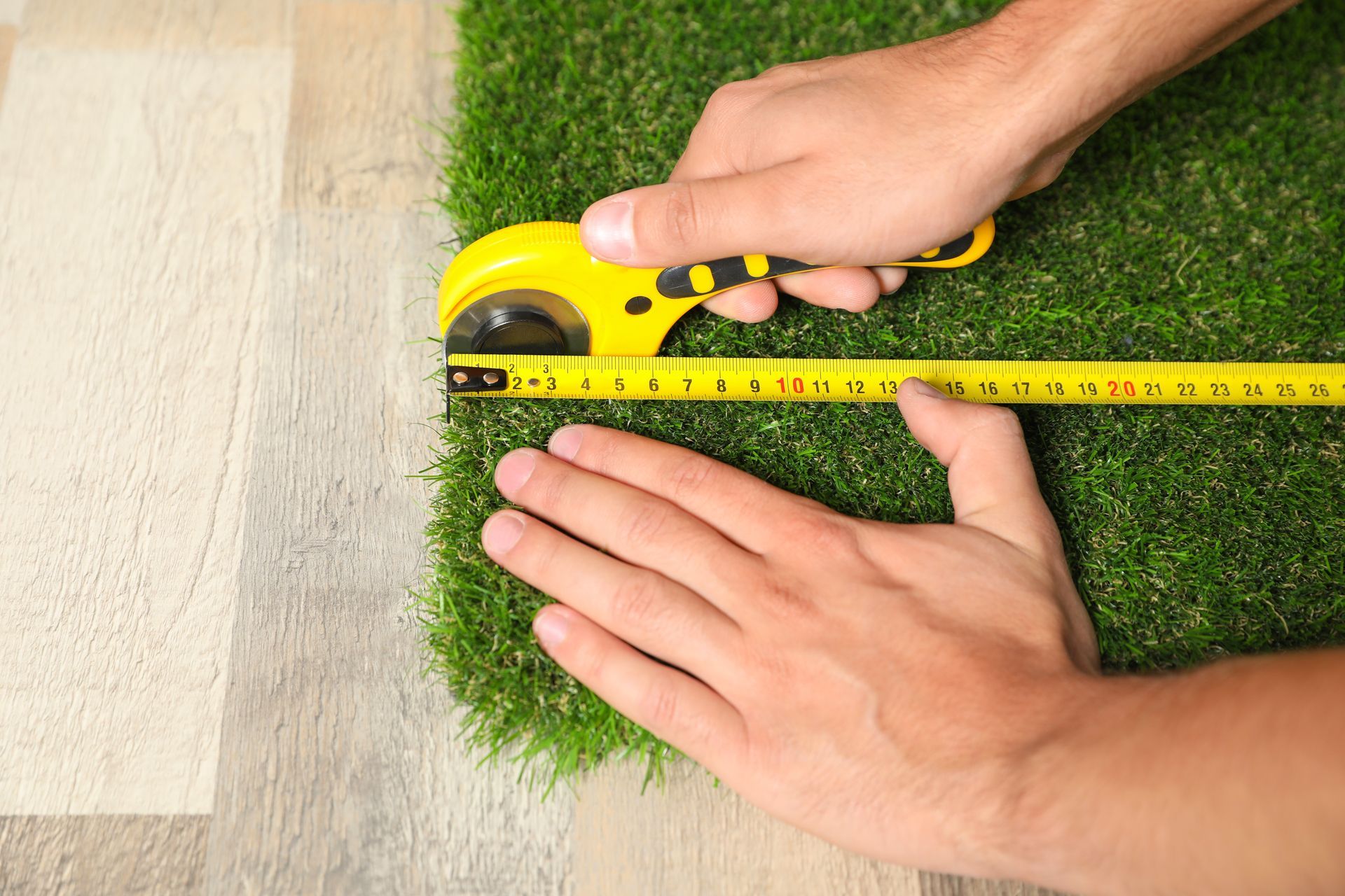 Fake grass being measured and cut