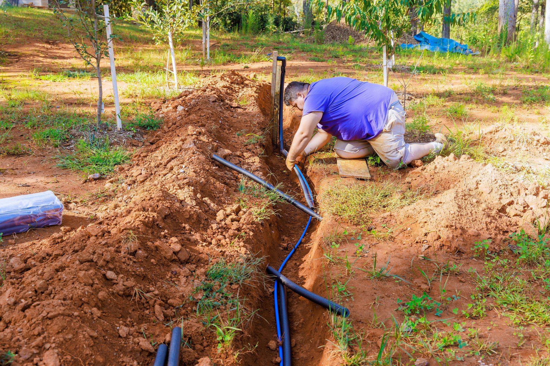Underground pipes for a sprinkler system being laid into trenches