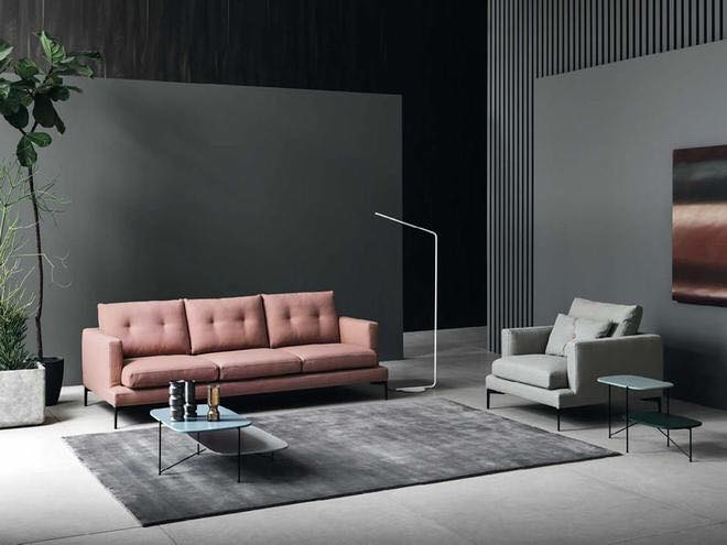Salotto moderno con divano rosa a tre posti e tappeto grigio