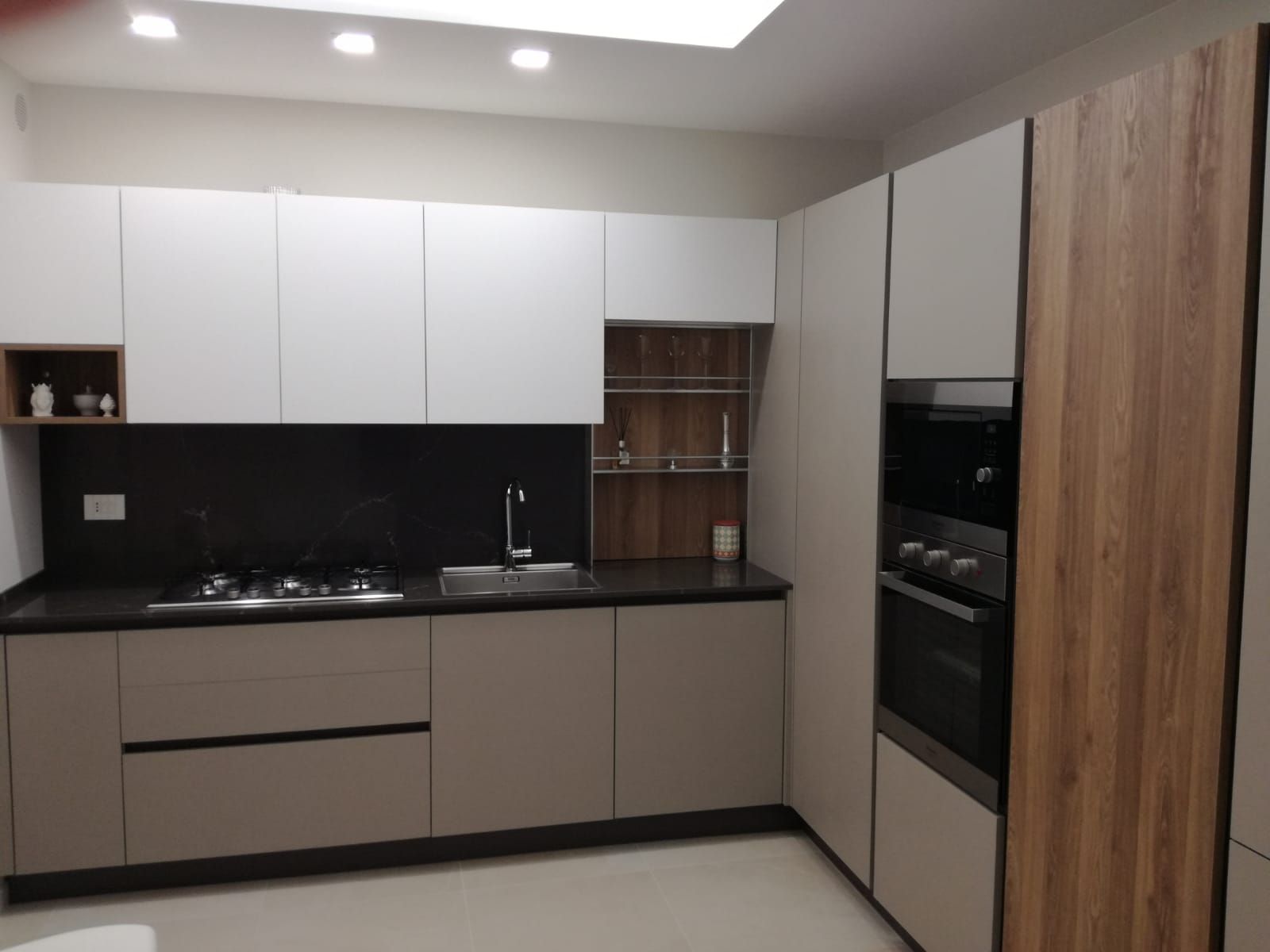 cucina con mobili bianchi e ripiani in legno