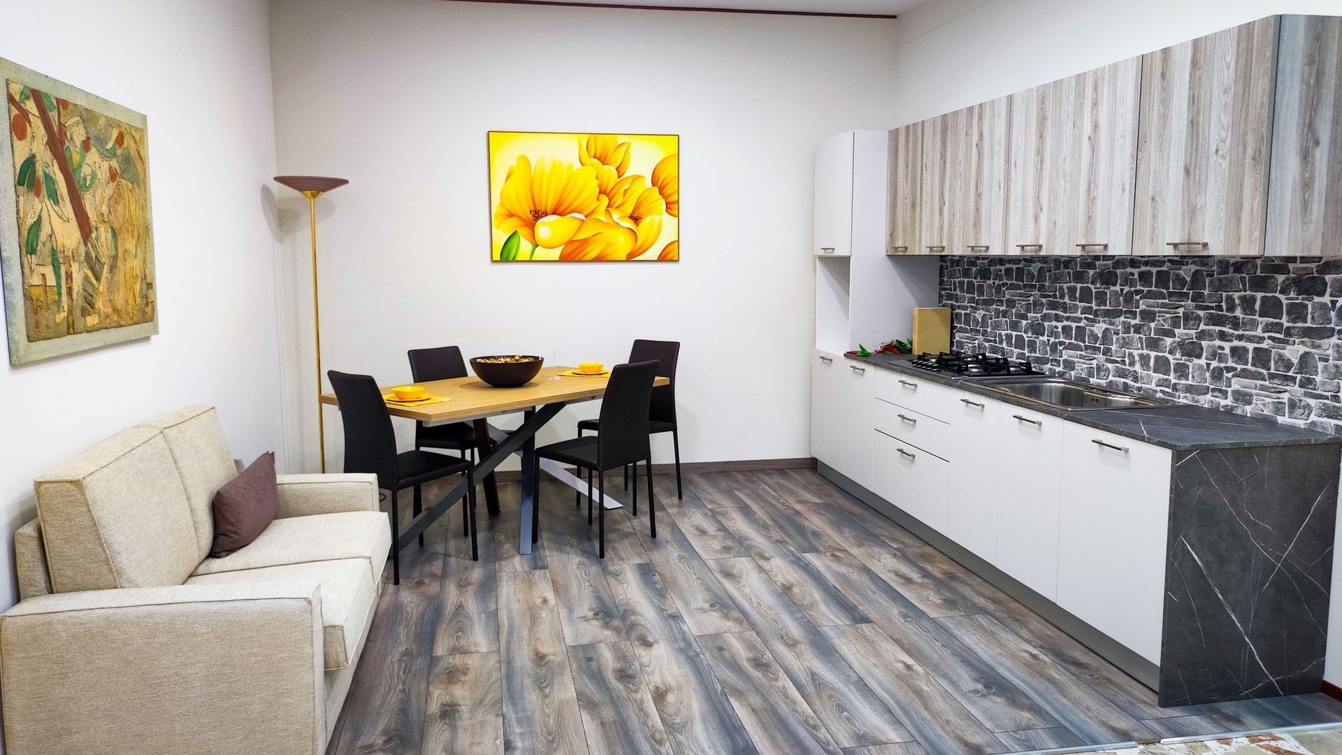 zona giorno con con divano, cucina, tavolo e sedie