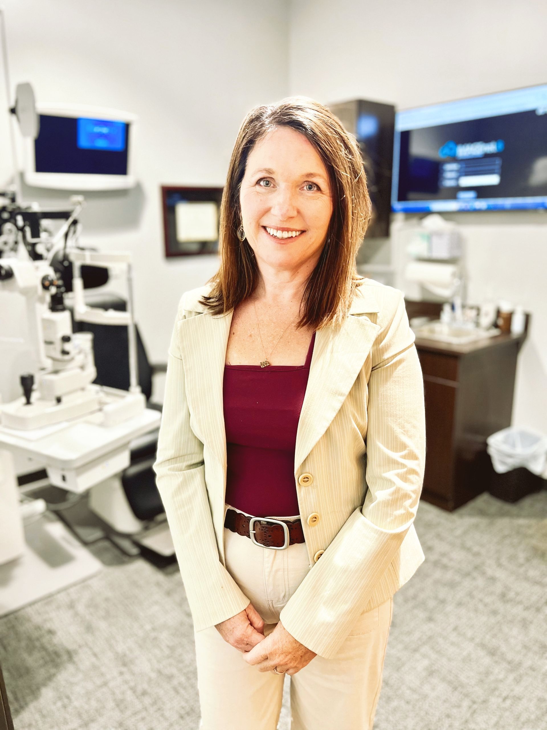 A woman in a white jacket and white pants is standing in a room.