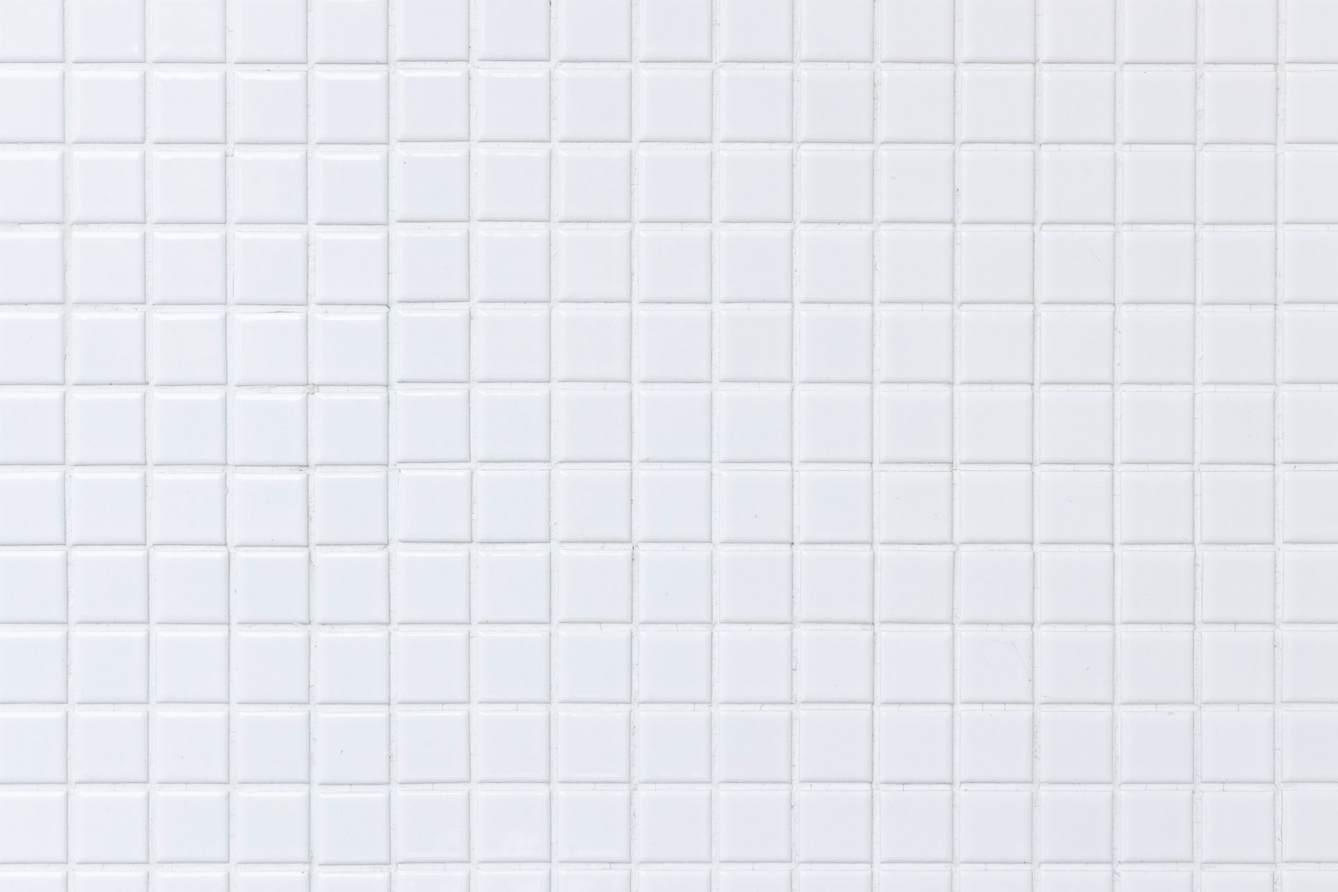 White square tiles on a wall, evenly spaced with visible grout lines.