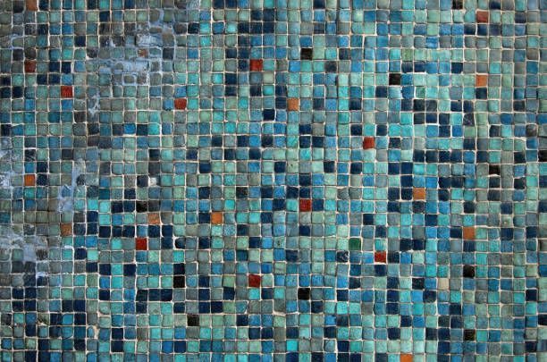 Blue and teal mosaic tile wall with scattered red and orange tiles.
