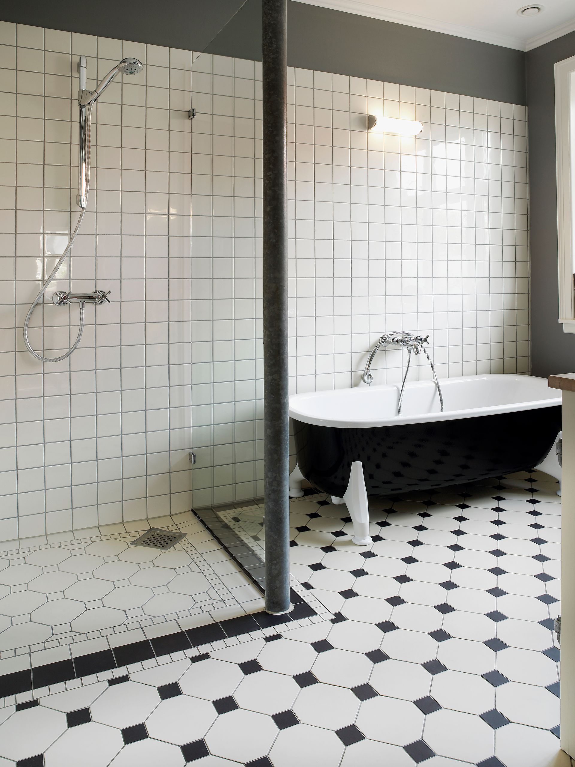 Black and white bathroom with clawfoot tub, tiled shower, and patterned floor.
