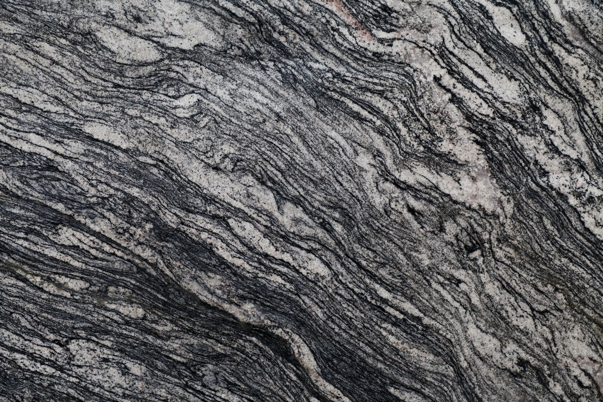Gray and black marbled rock with swirling, layered patterns.