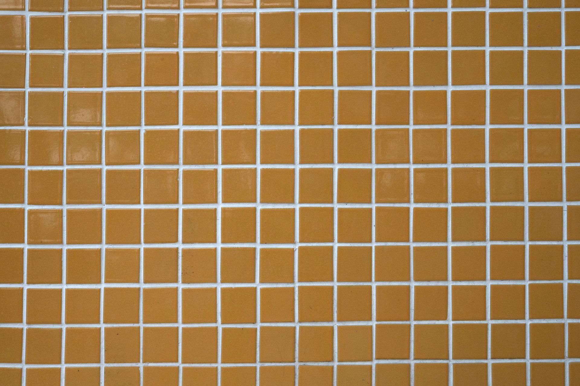 Brown square tiles with white grout filling the frame.