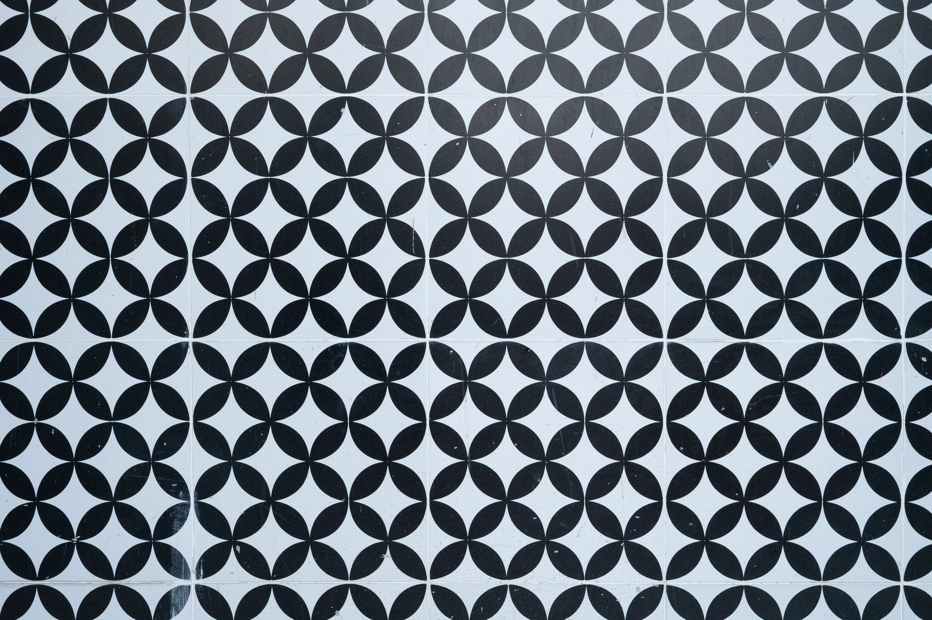 Black and white tiled floor with a repeating quatrefoil pattern.