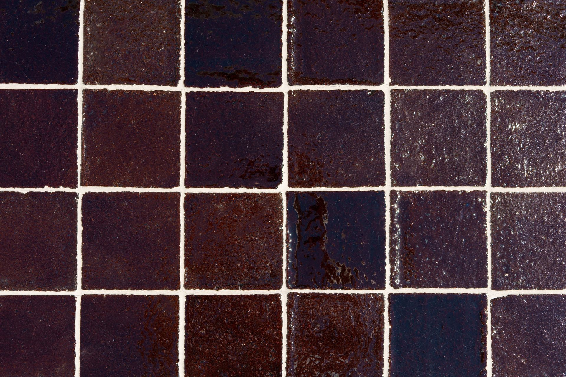 Dark brown square tiles with white grout.