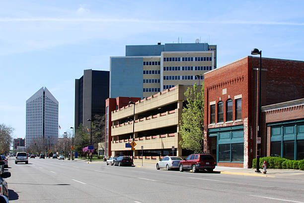 Street view of downtown buildings with a multi-story parking garage and clear sky.