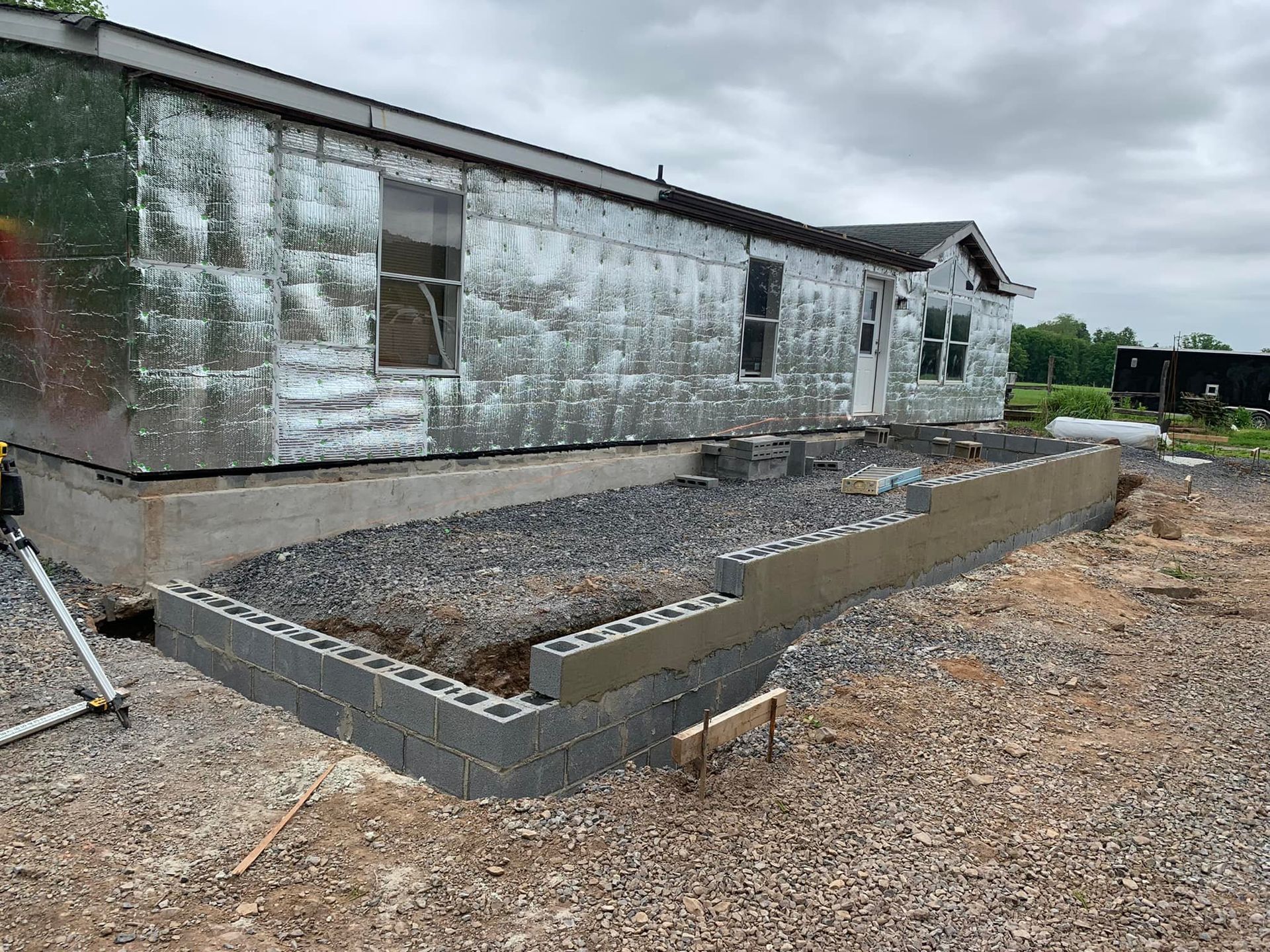 A mobile home is being built on a gravel lot