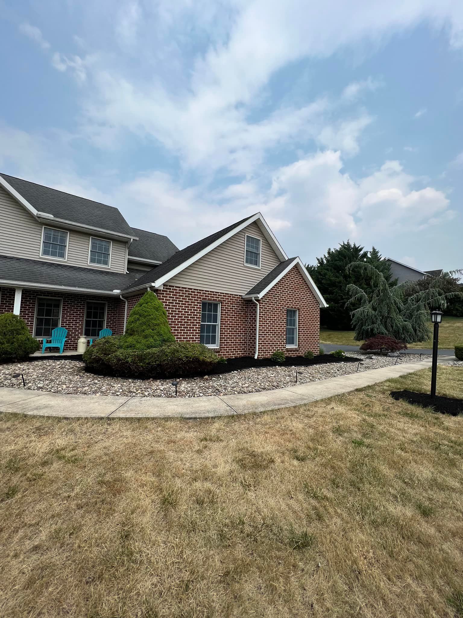 A large brick house with a walkway leading to it.