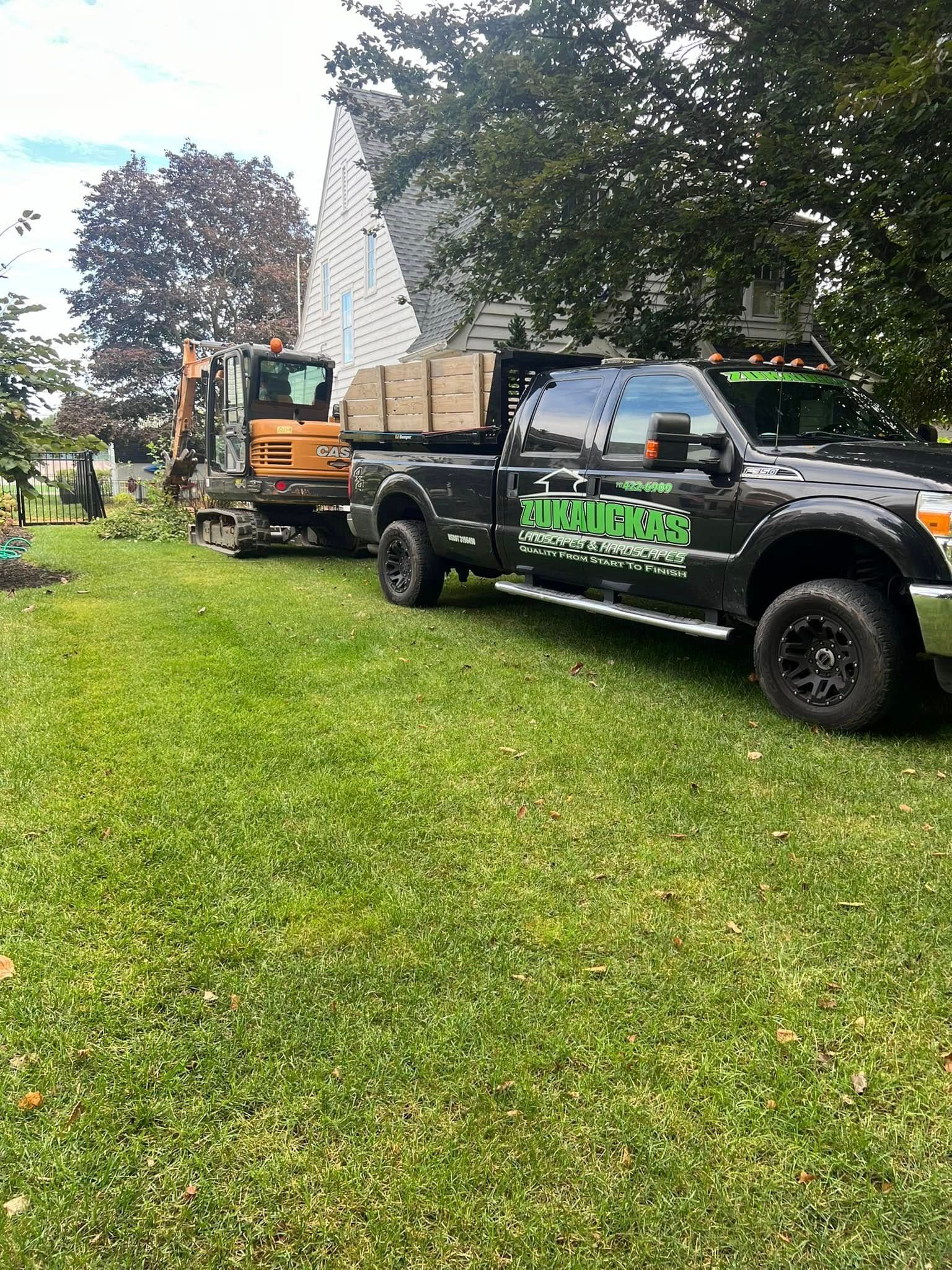 Two trucks are parked in a grassy yard next to each other.