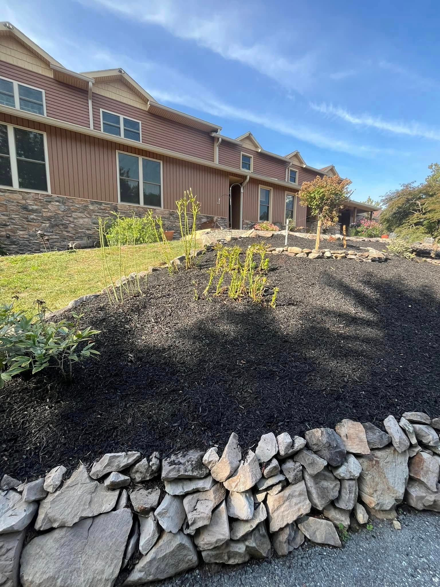 A large house with a stone wall in front of it.