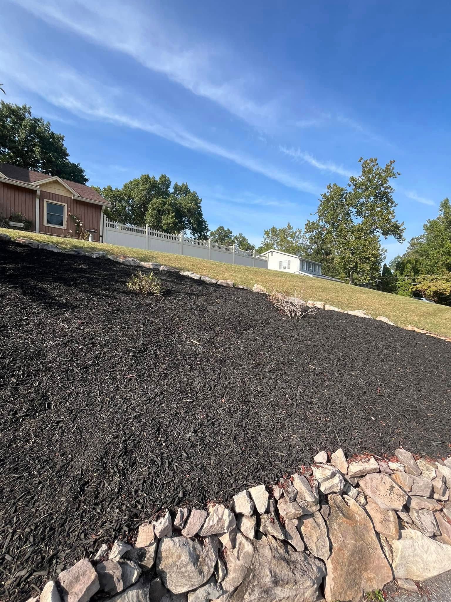 There is a house in the background and a rock wall in the foreground.
