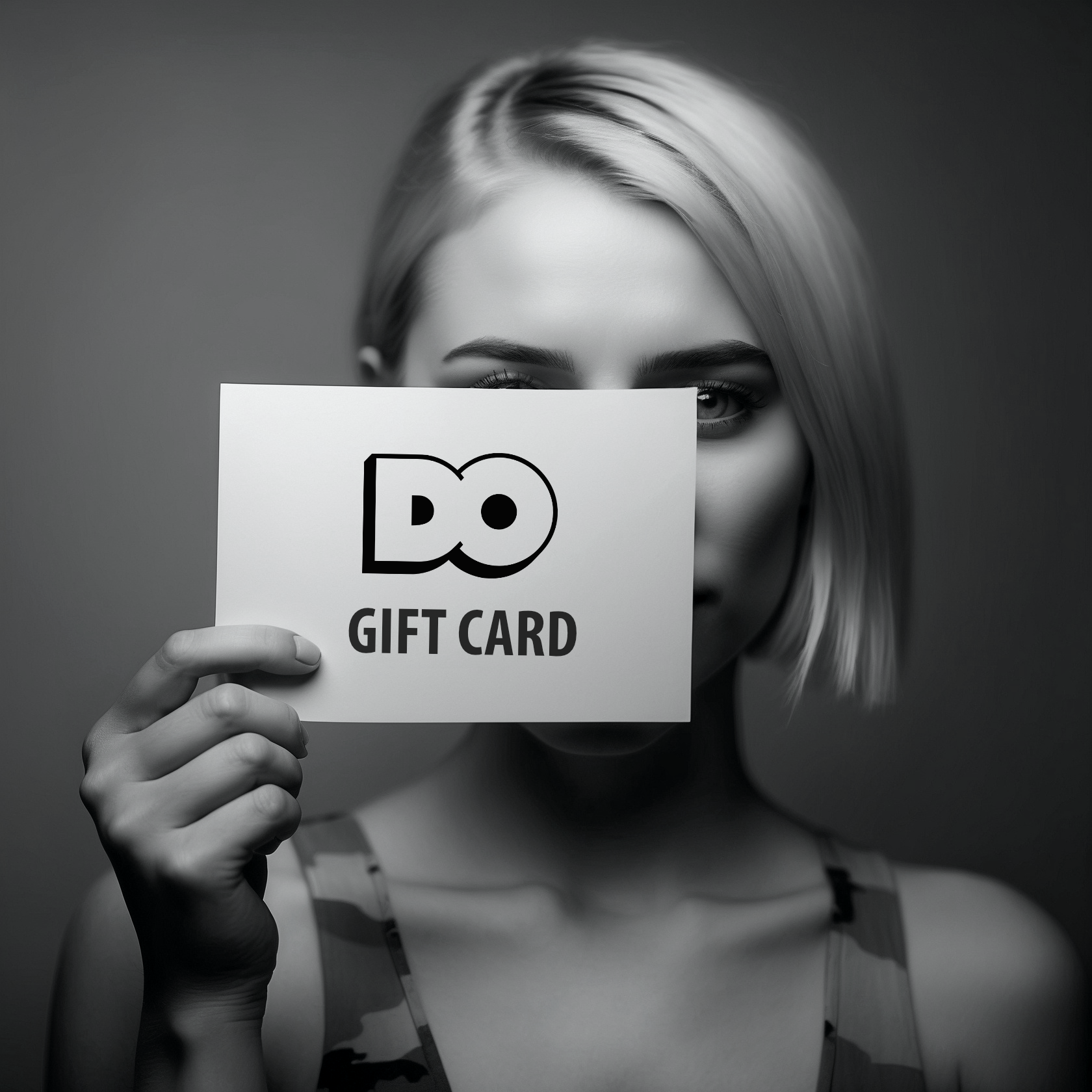 A woman is holding a gift card in front of her face