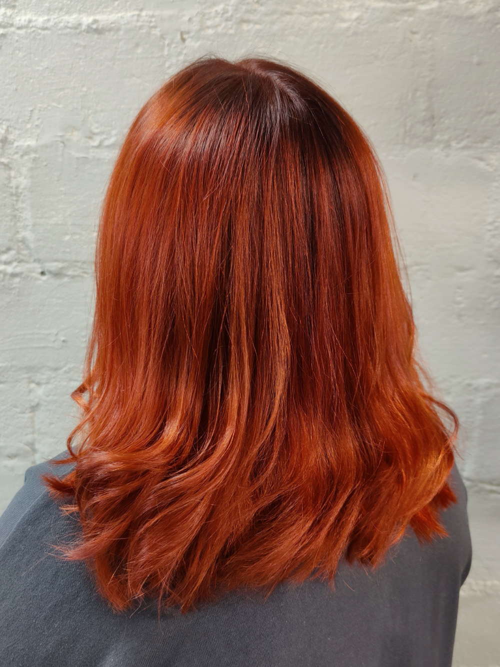 The back of a woman 's head with long red hair.