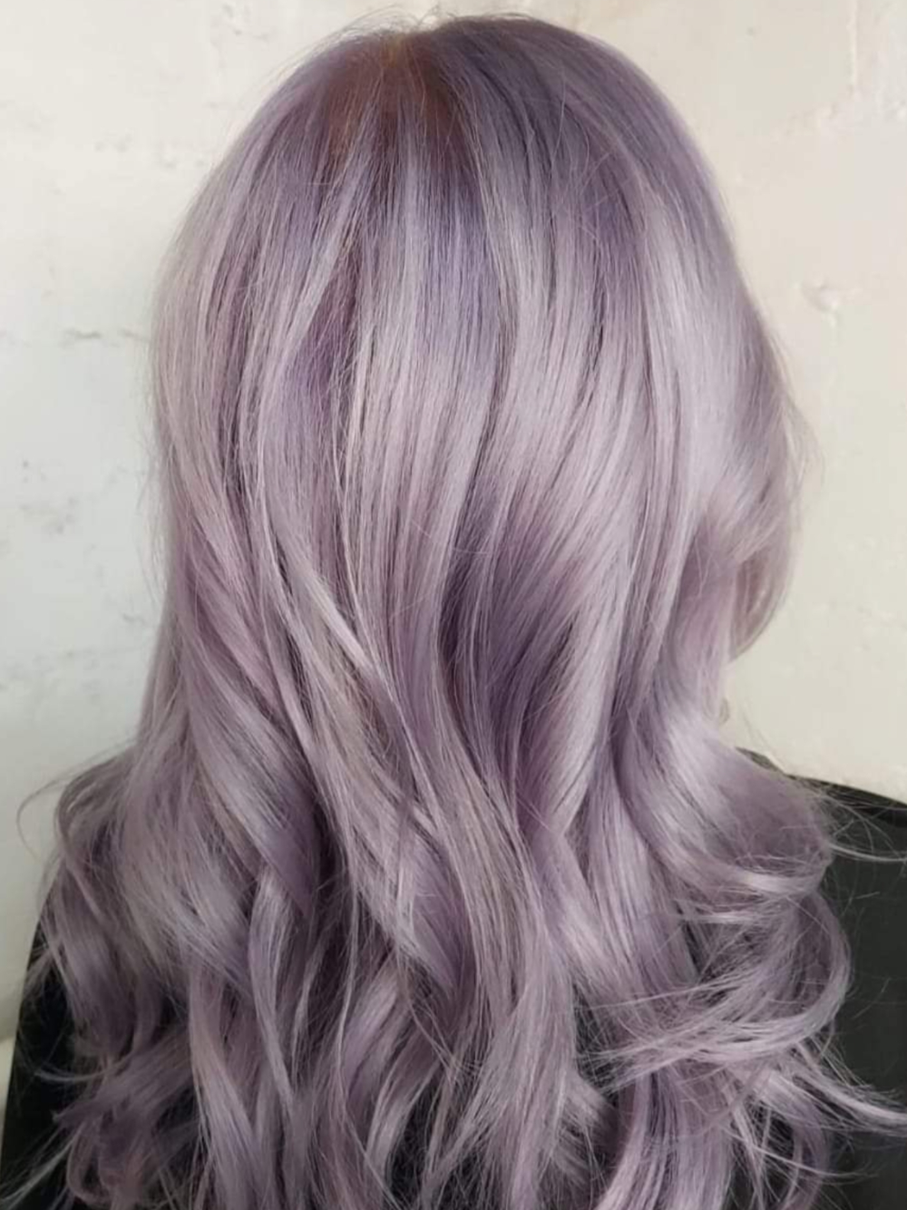 The back of a woman 's head with purple hair.