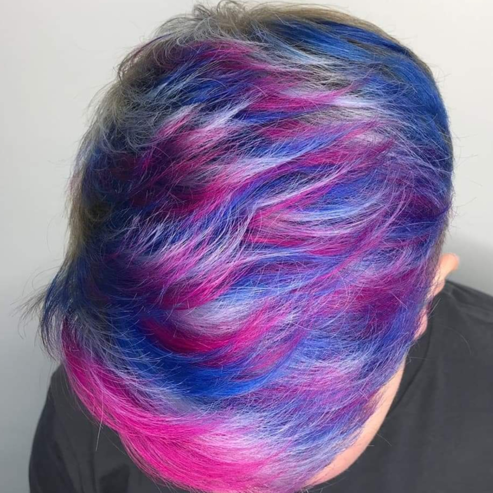 A close up of a person 's head with blue and pink hair.