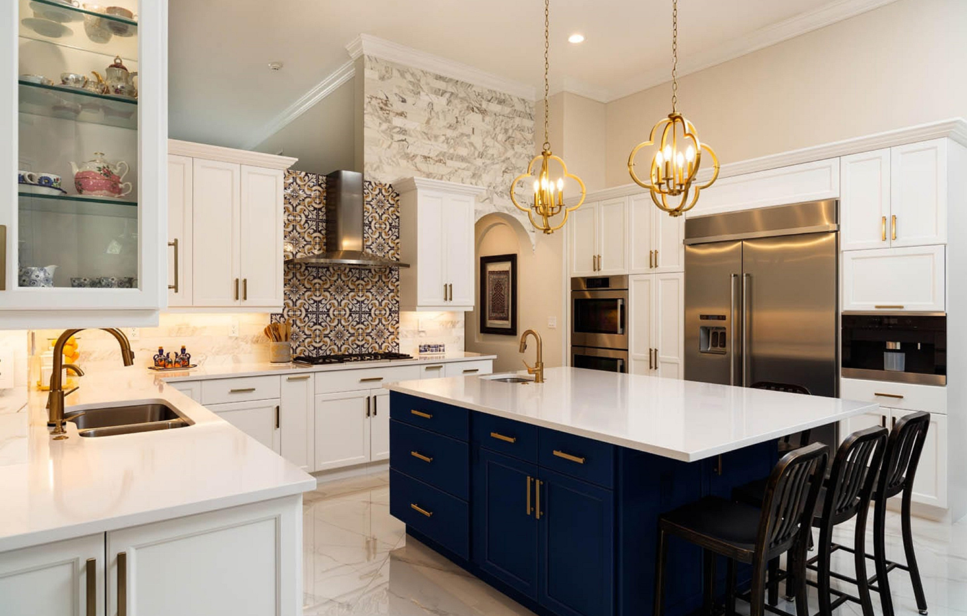 A kitchen with white cabinets , blue cabinets , stainless steel appliances , and a large island.