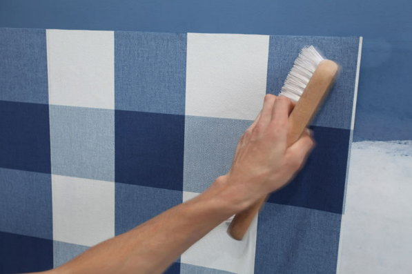 A person is painting a blue and white checkered wall with a brush A person is painting a blue and white checkered wall with a brush