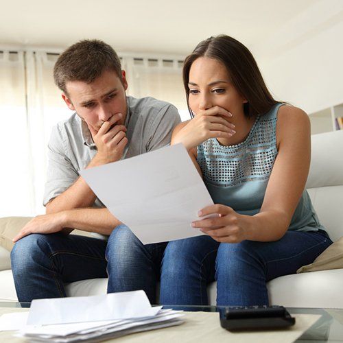 Couple Checking at Debt in a Paper — Tampa, FL — Debt Relief Law Offices of Tampa Bay