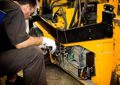 Forklifts Maintenance — Man Repairing a Forklift in Houston, TX