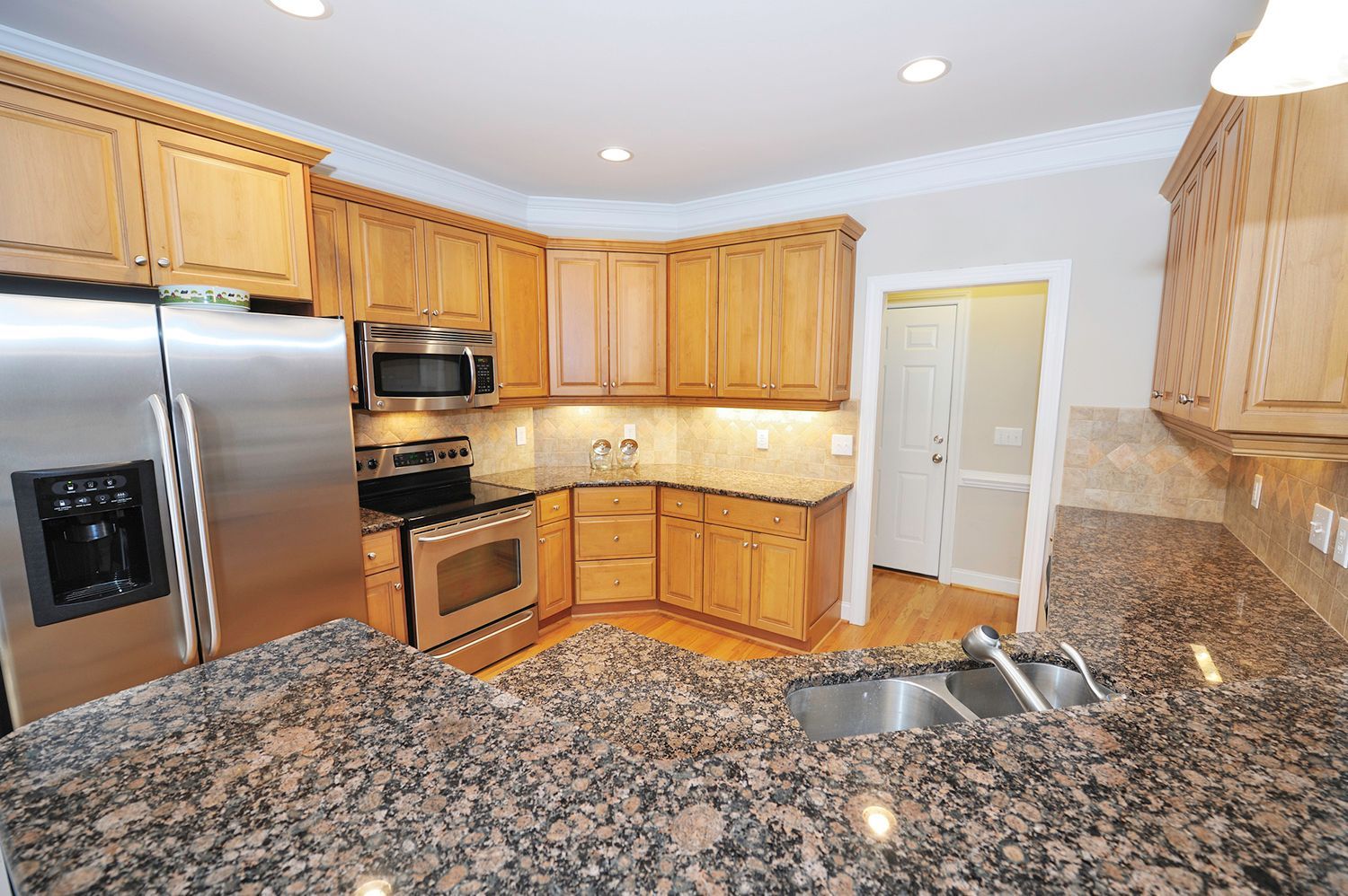 A kitchen with granite counter tops and stainless steel appliances