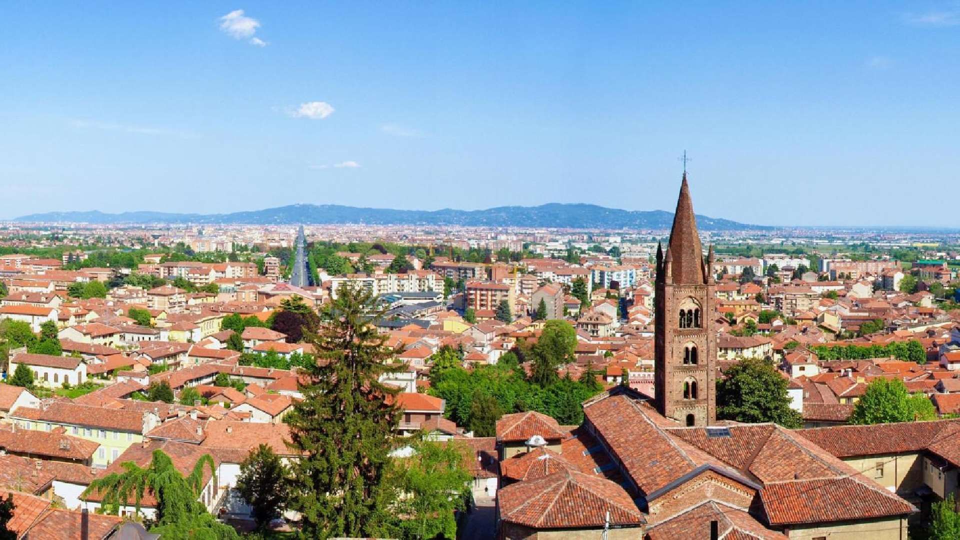 Vista di Collegno con campanile e montagne sullo sfondo