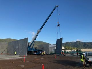 A Crane Is Lifting A Large Piece Of Metal On A Construction Site — S & K Gallaway Concreting In West Mackay, QLD