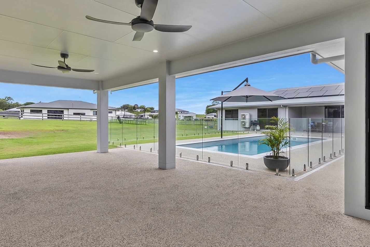 A Concrete Walkway Leading To A House With A Wooden Fence — S & K Gallaway Concreting In West Mackay, QLD